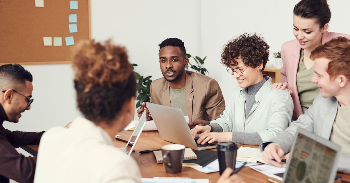 Equipe discutindo estratégias práticas em reunião com laptop aberto